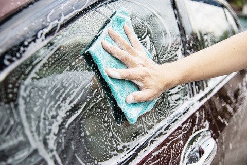Professional hand washing technique using blue microfiber cloth and soap for safe exterior cleaning